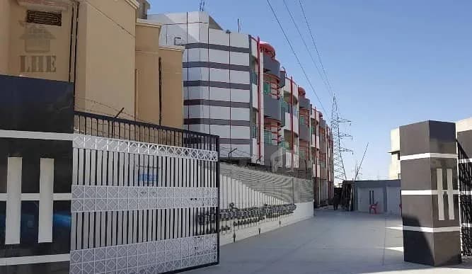 Apartment blocks behind the boundary wall of Chiltan Housing Scheme, Quetta